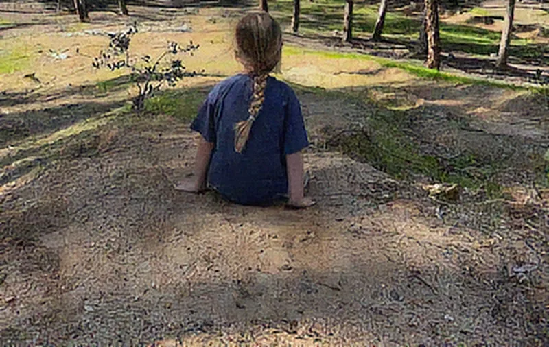 Denoised: grainy park photo of a child sitting on dirt